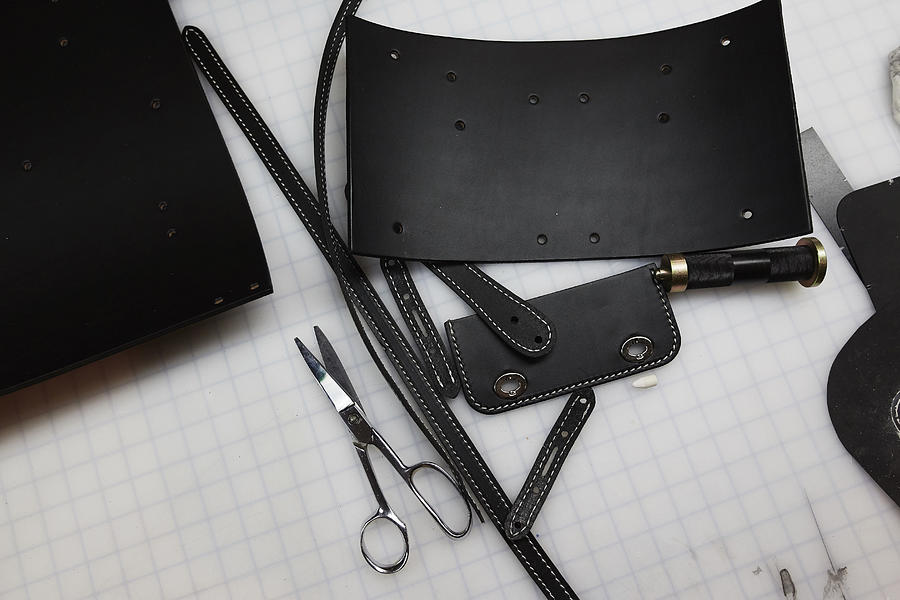 A handmade blue leather bag, strap, component part parts, scissors and hand tools. Photograph by Mint Images