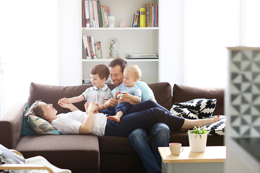 A happy family on a sofa Photograph by Catherine Delahaye