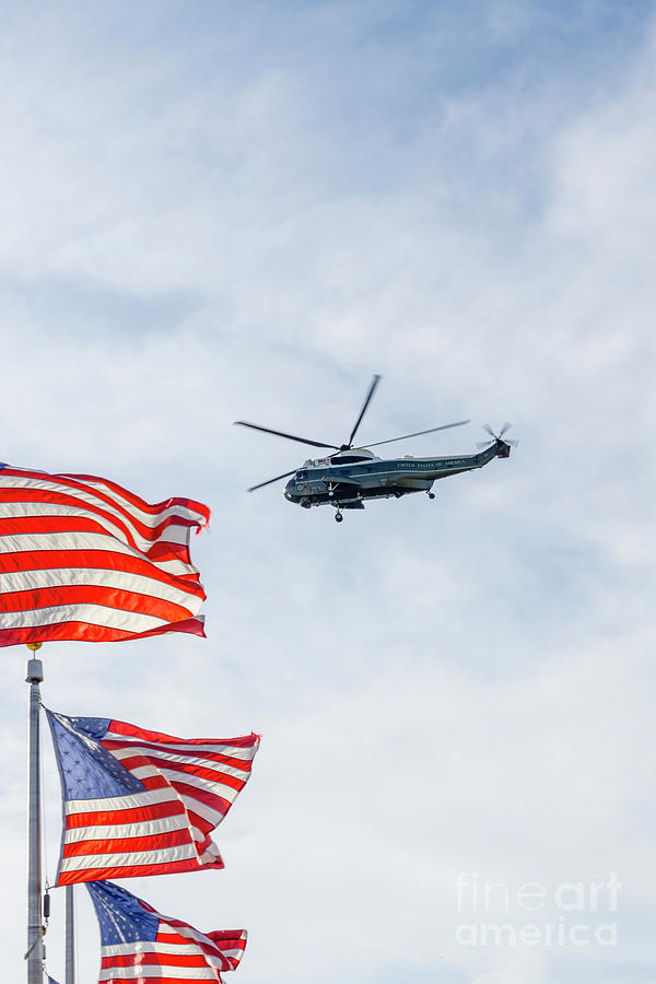 A helicopter from the US presidential fleet flies over the US fl Photograph by William Kuta