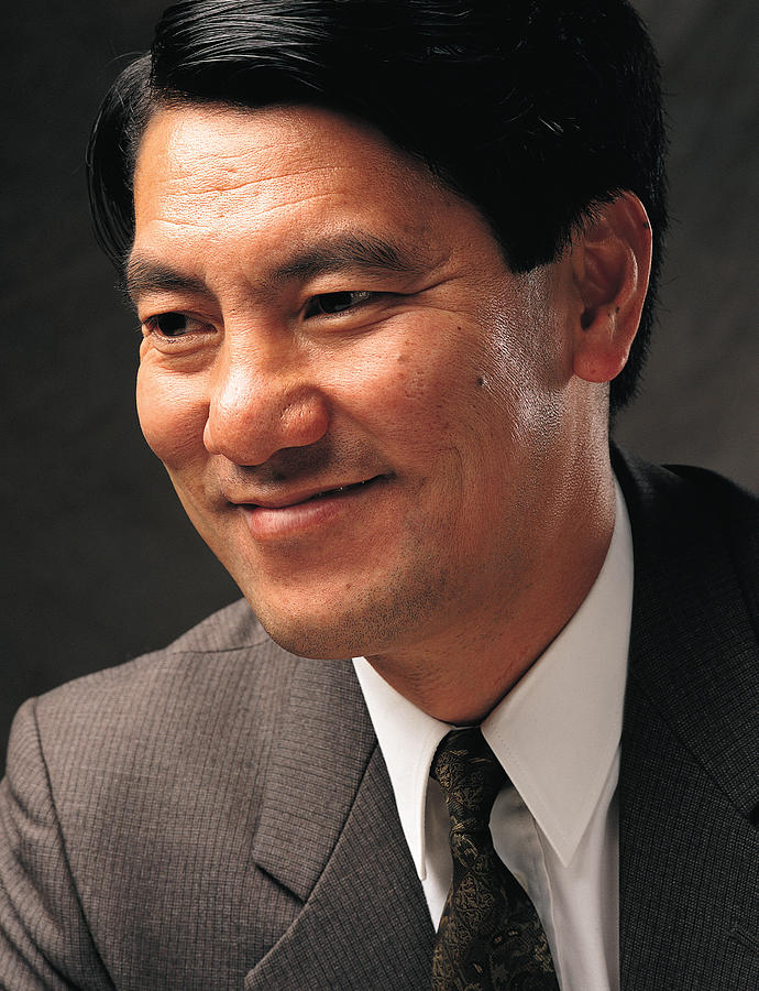 A Hispanic Businessman Wearing A Gray Suit With Shirt And Tie Smiles Photograph by Photodisc