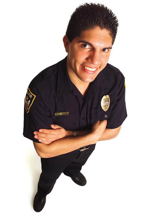 A Hispanic Male Police Officer In Uniform Smiles As He Looks Up At The Camera Photograph by Photodisc