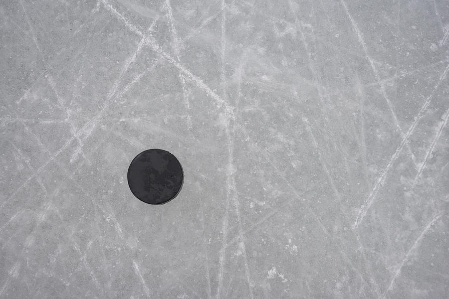 A hockey puck on an ice rink Photograph by Scott Markewitz