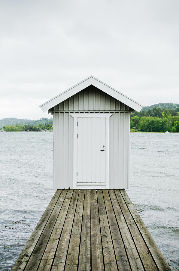 A hut at the end of a wooden lake pier. Photograph by Roman Pretot