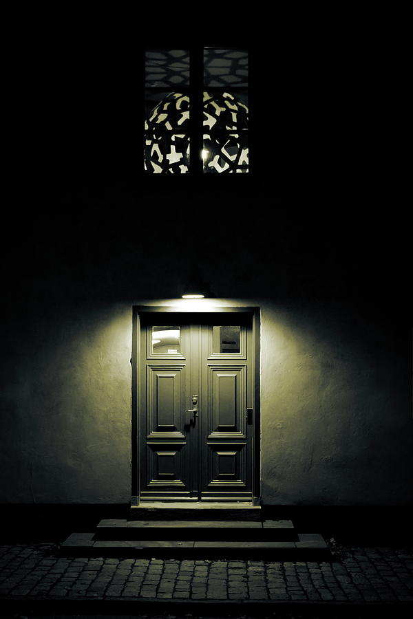 A light cone is illuminating the wooden door to a town house in a dark night Photograph by Ulrich Kunst And Bettina Scheidulin