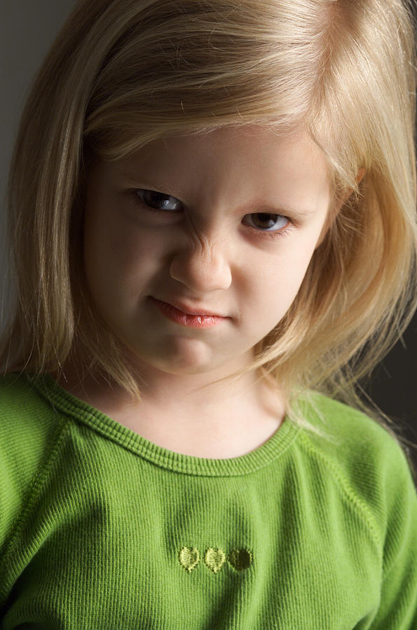 A Little Blond Girl In A Green Shirt Scrunches Her Nose In An Expression Of Annoyance Photograph by Photodisc