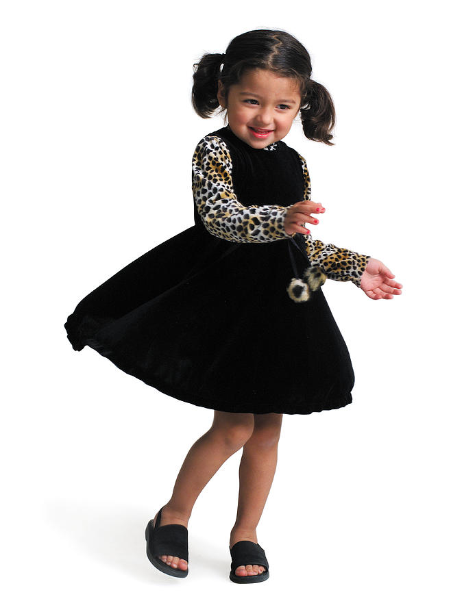 A Little Ethnic Girl In A Black Dress With Leopard Print Sleeves Spins And Dances While Smiling Photograph by Photodisc