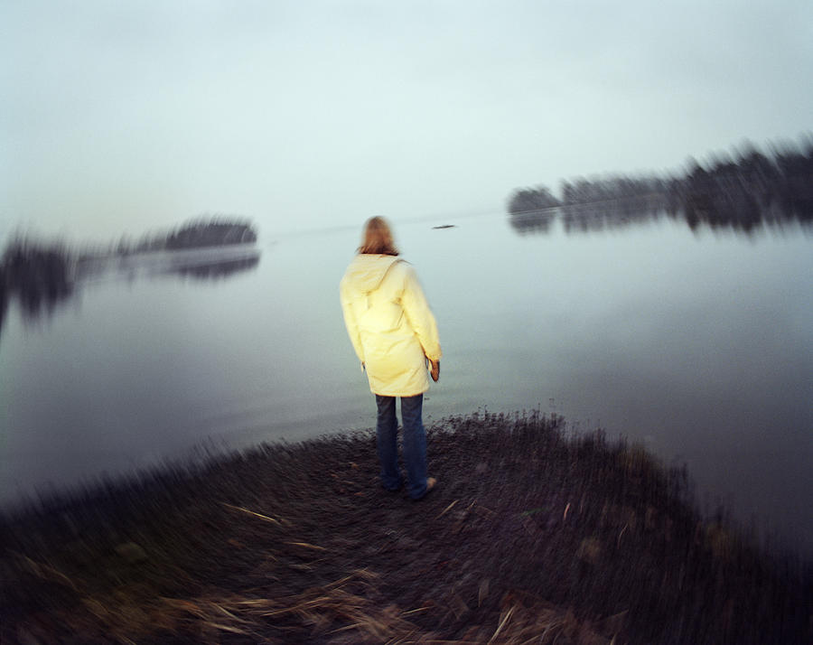 A lonely woman by a lake Sweden. Photograph by Per Eriksson