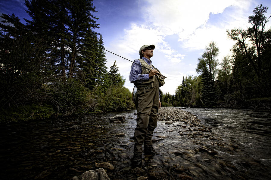 A male fly fisherman standing near a stream ready to fish Photograph by Robb Reece