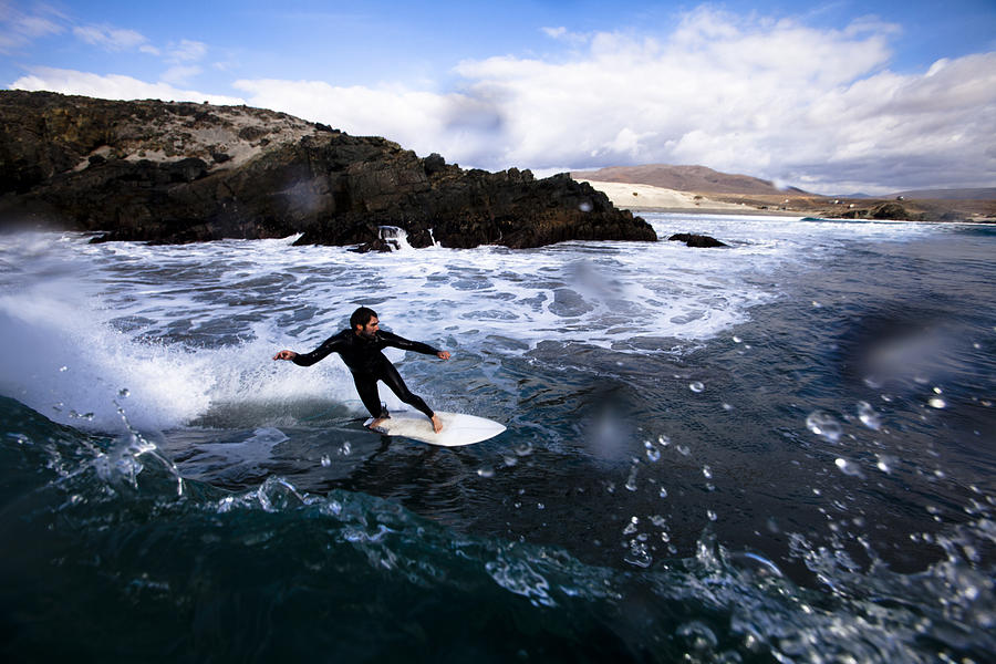 A male surfer bottom turns around a breaking wave while surfing in Northern Baja, Mexico. Photograph by Kyle Sparks