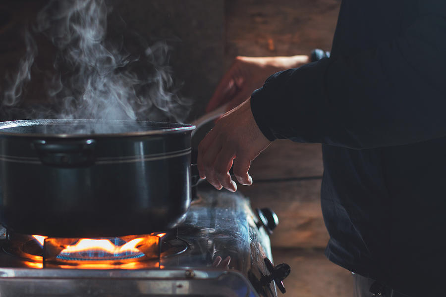 A man cooking in a rustic cabin Photograph by Catherine Marois