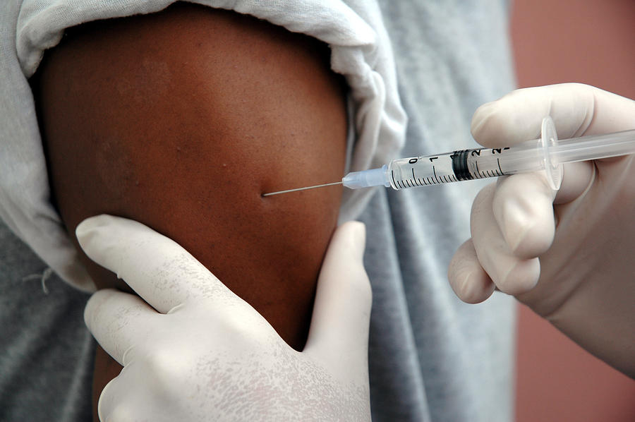 A man receiving a vaccine shot Photograph by Sean_Warren