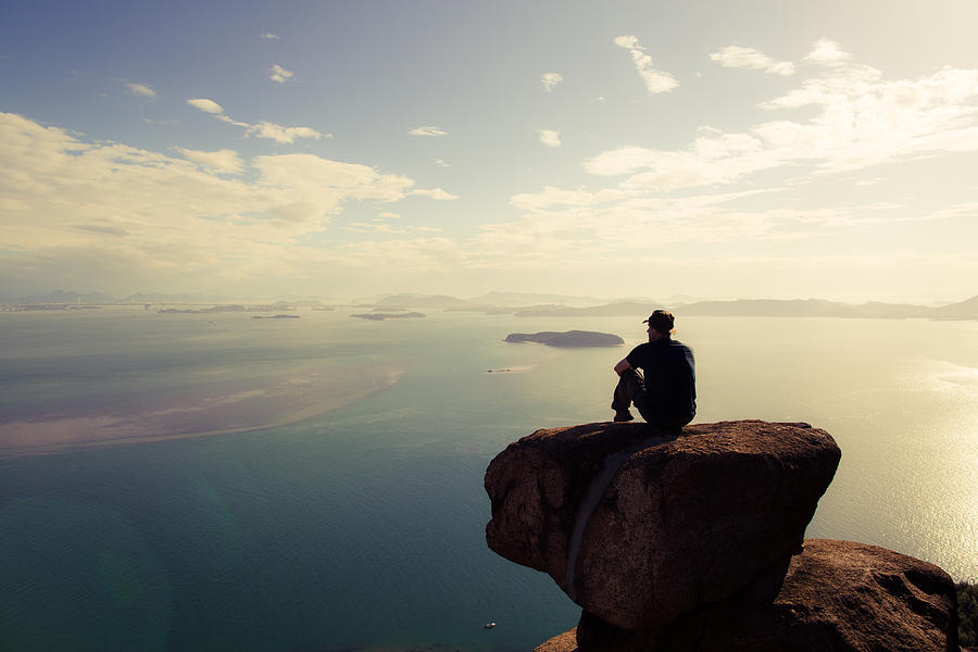 A man sitting on a mountain wtching the sun set Photograph by Trevor Williams