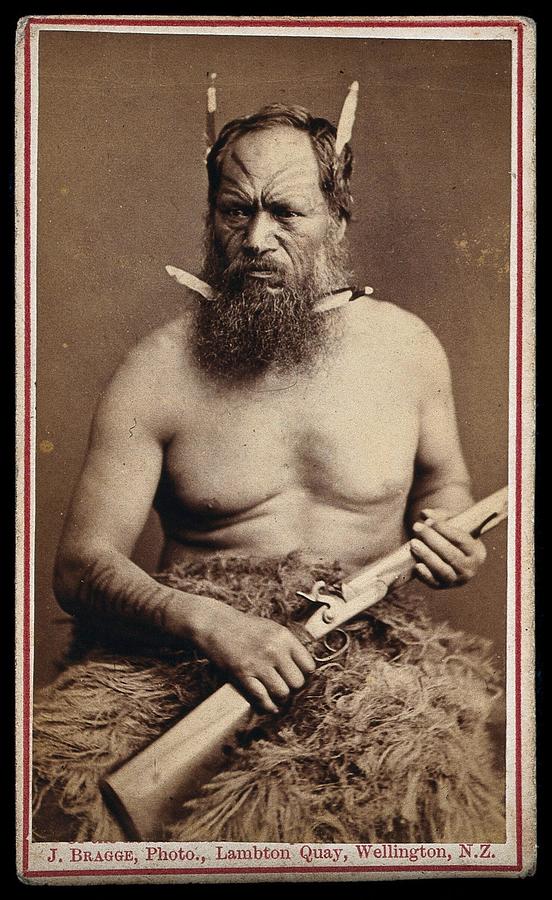 A Maori man with a tattoed face, holding a rifle. Photograph by J. Bragge Painting by Artistic Rifki