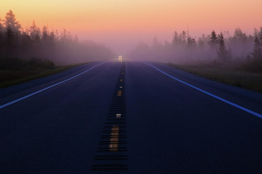 A misty sunrise on a highway in Northern Michigan. Photograph by Rob Huntley