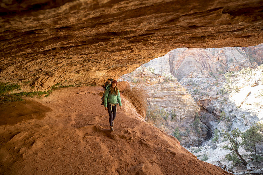 A mother and her son hiking a scenic trail through a cave Photograph by Jordan Siemens