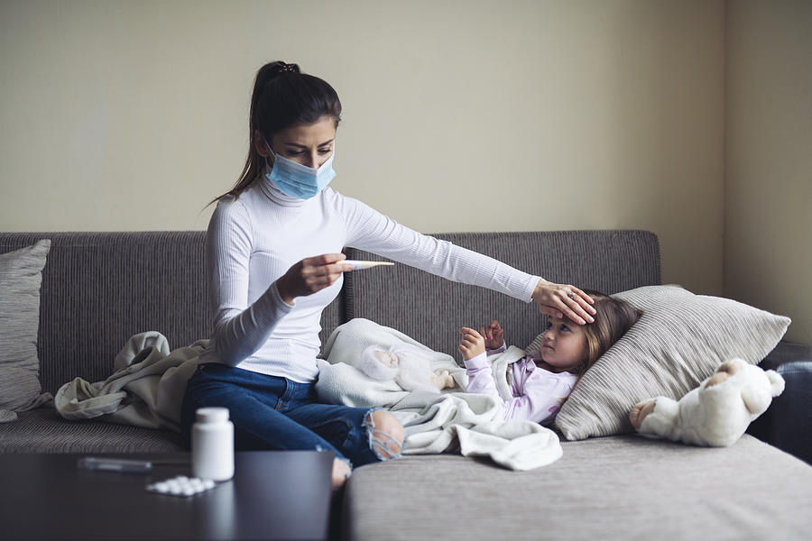 A Mother Measure Temperature On Her Sick Child At Home. Photograph by ArtistGNDphotography