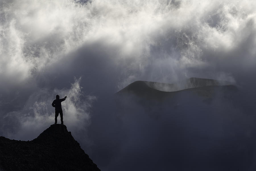 A mountanier man standing in front of a volcano Photograph by Inigo Cia