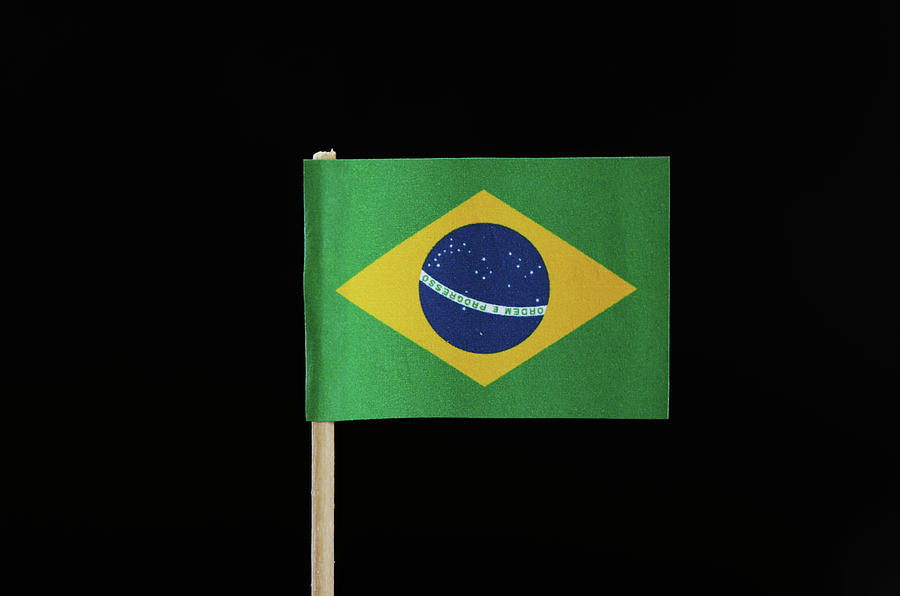 A national flag of Brazil on toothpick on black background. A green field with the large yellow diamond. In the middle of circle there is blue field in form circle with writting Order and Progress Photograph by Vaclav Sonnek