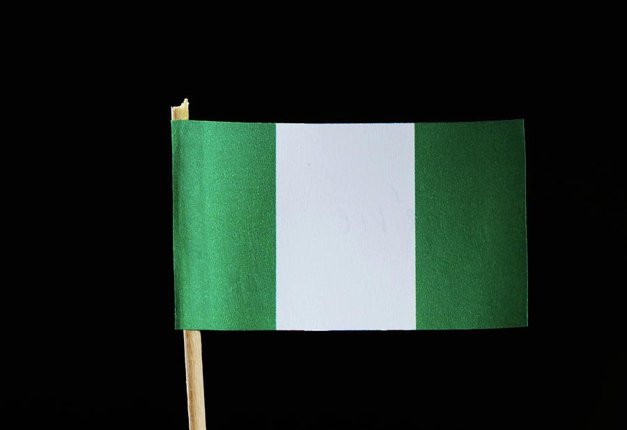 A national flag of Nigeria on toothpick on black background. Nigerian flag contain green and white colour. Photograph by Vaclav Sonnek
