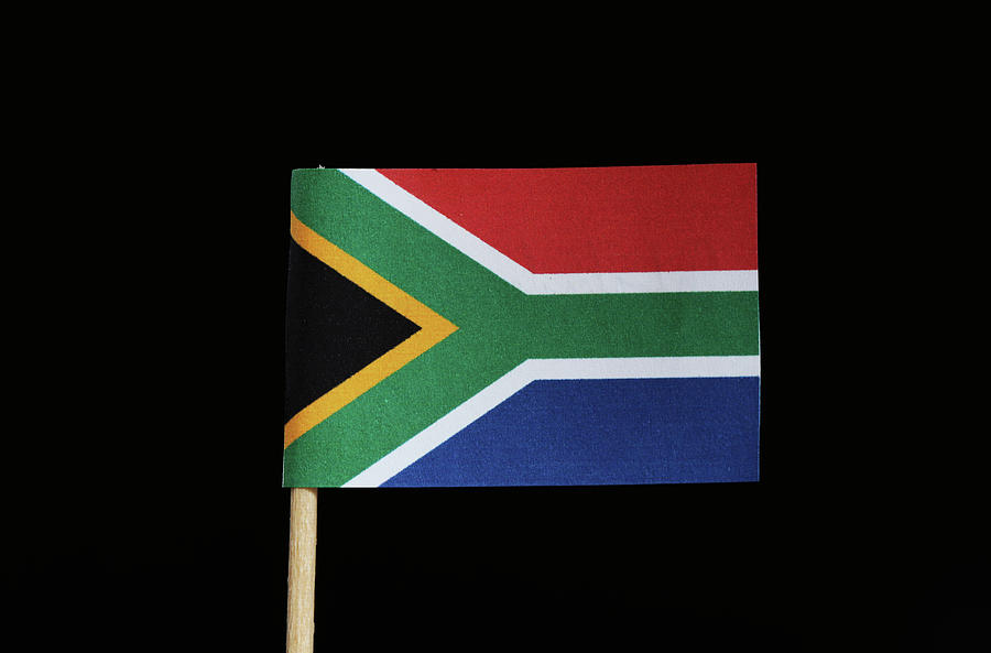A national flag of South Africa on toothpick on black background. The flag has six colours yellow, white, red, blue, black, green. Photograph by Vaclav Sonnek