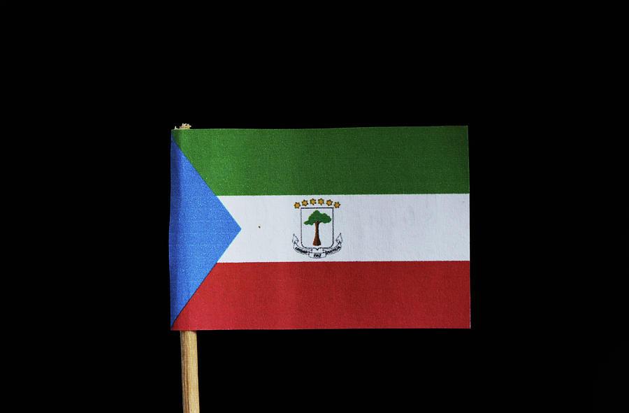 A official flag of Equatorial Guinea on toothpick on black background. Equatorial Guinea is located in central africa.  Photograph by Vaclav Sonnek