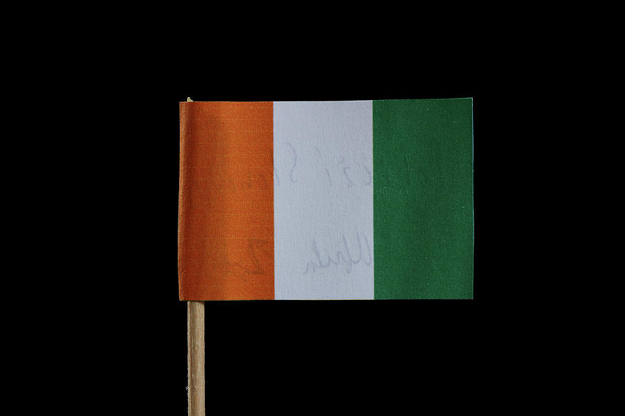 A official flag of Ivory Coast on toothpick and on black background. The Ivory Coast is located in west africa. Photograph by Vaclav Sonnek
