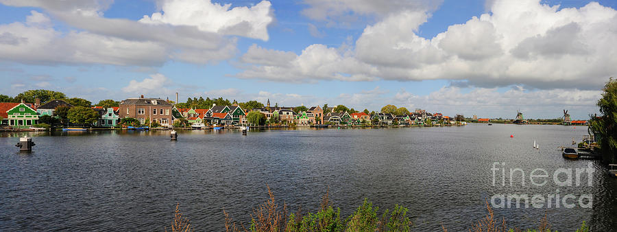 A Panoramic view of Zaandam Schans and a row of old world Dutch architecture homes along the river. Photograph by Gunther Allen