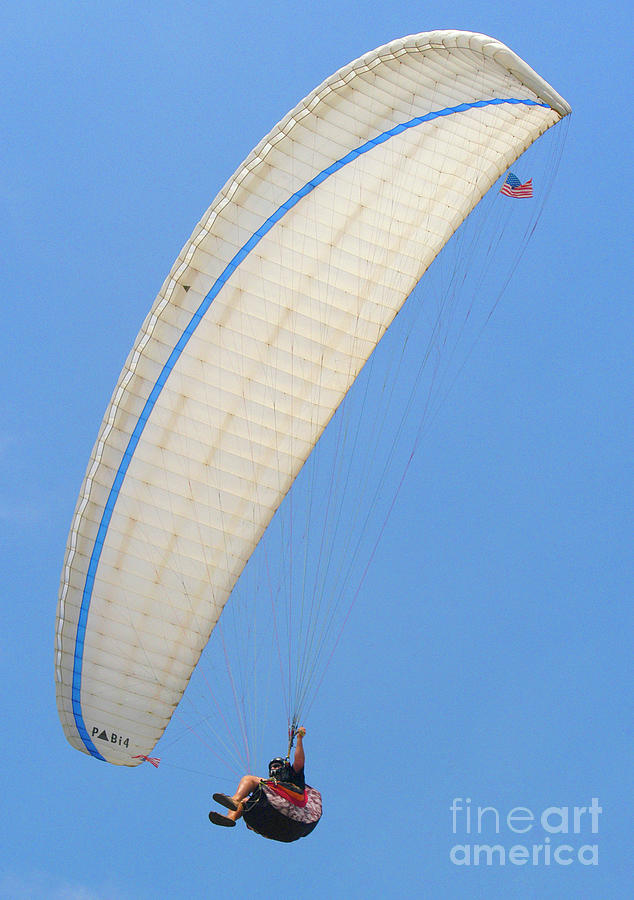 A paraglider sits comfortably in the air as the wind carries him above the Pacific Ocean.   Photograph by Gunther Allen