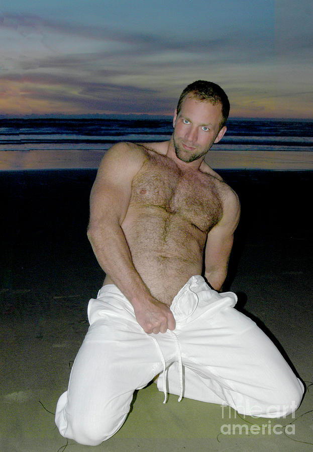 A playful sexy and hairy man poses on the beach at sunset. Photograph by Gunther Allen