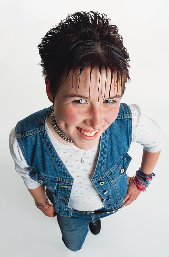A Pretty Caucasian Teenage Girl With Spiked Brown Hair Is Wearing A Chain Choker And Jeans While Smiling Up At The Camera Showing Cute Dimples Photograph by Photodisc