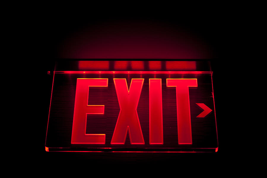 A red Illuminated exit sign on black Photograph by 35007