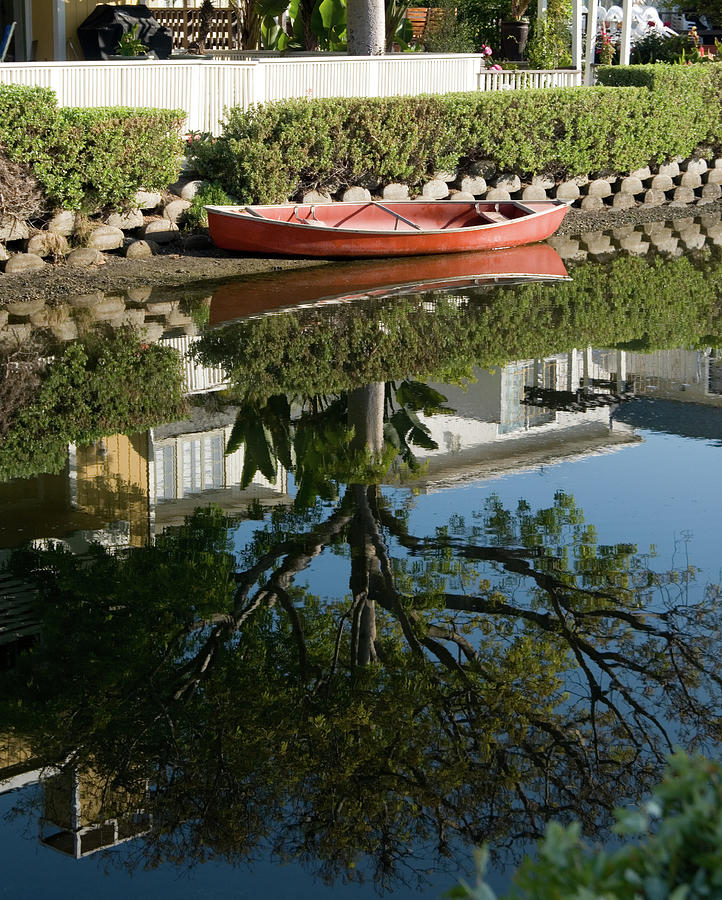 A red row boat reflecting in still waters Photograph by Mark Stout