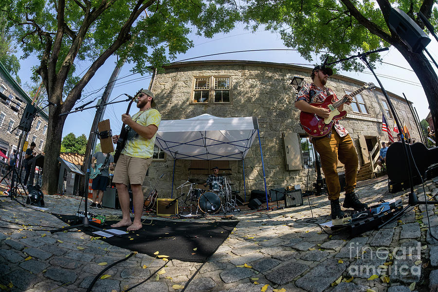 A rock band plays outdoors at the old train station during a mus Photograph by William Kuta