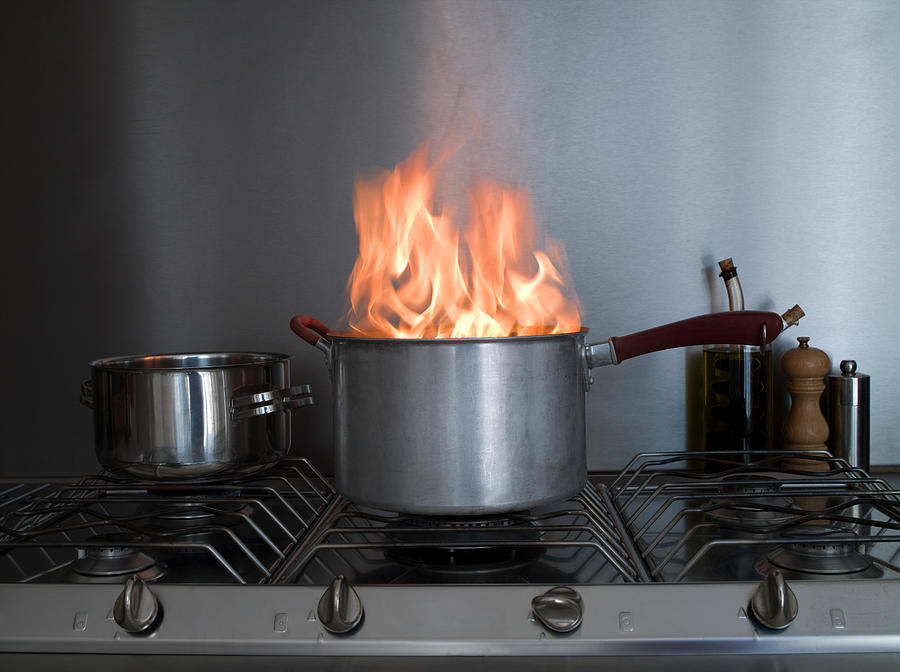 A saucepan on fire Photograph by Image Source