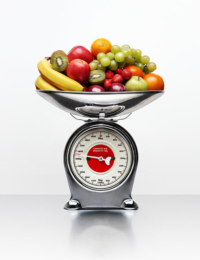 A selection of fruit on a weighing scale Photograph by Jonathan Kitchen