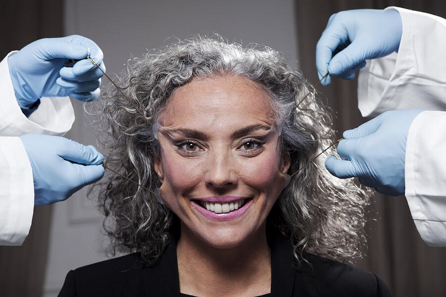 A senior woman has face pulled by surgeons Photograph by Vincent Besnault