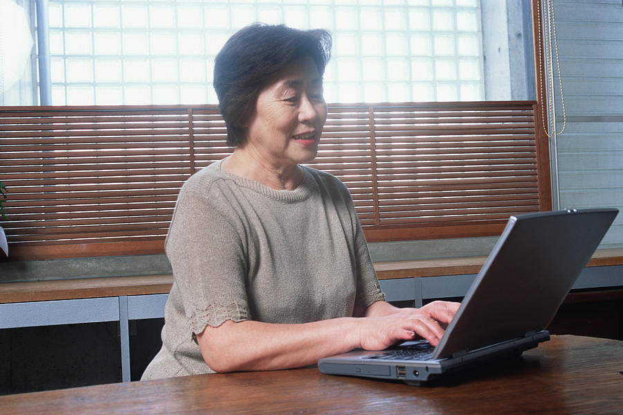 A senior woman using a computer Photograph by Mixa