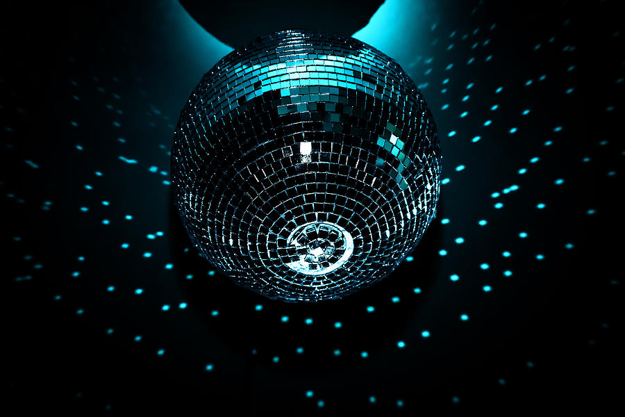 A Shiny Disco Ball Hangs On A Black Background In A Nightclub. Glare On A Dark Background From The Disco Ball Photograph