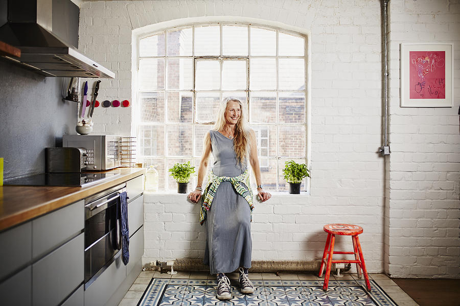 A shot of funky older woman standing in kitchen Photograph by Kelvin Murray