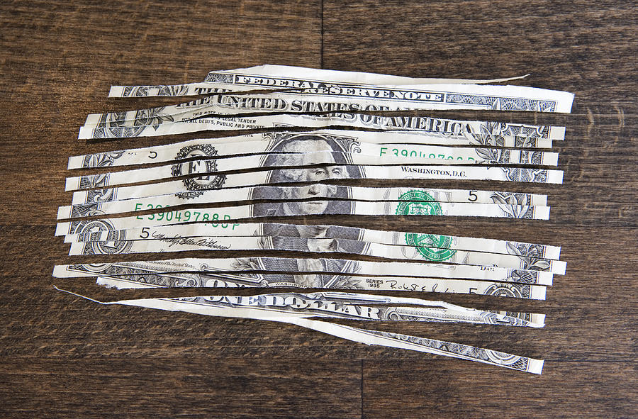 A shredded one dollar note on a wooden table Photograph by Halfdark