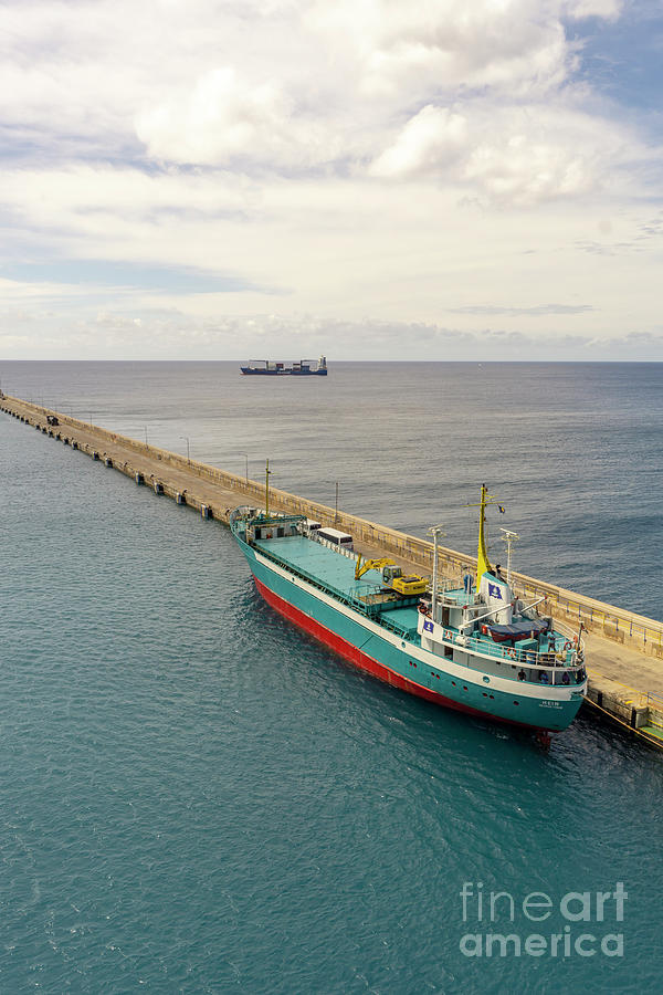 A small blue freighter in the port of Bridgetown, Barbados, an i Photograph by William Kuta