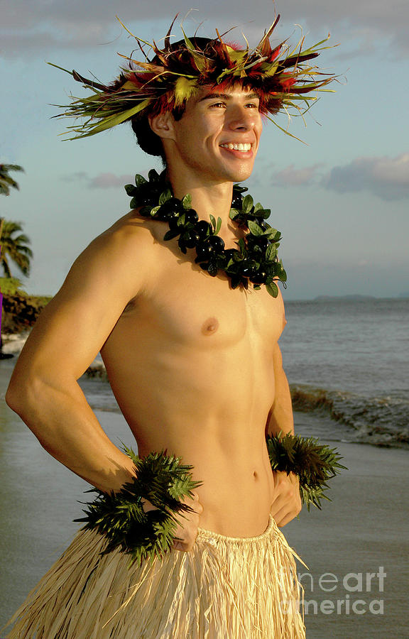 A smiling male hula dancer poses on the beach. Photograph by Gunther Allen