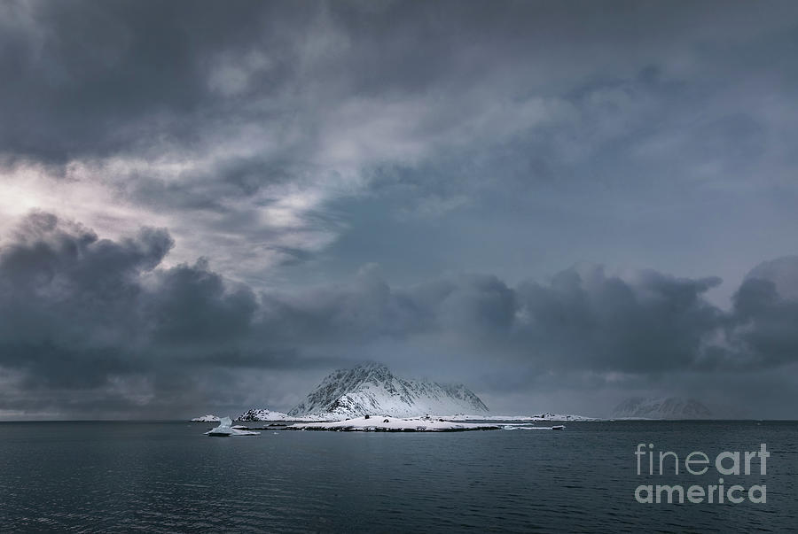A snow covered mountain and icebergs rising from the arctic sea in Svalbard, Arctic Circle, with dark and moody sky Photograph by Jane Rix