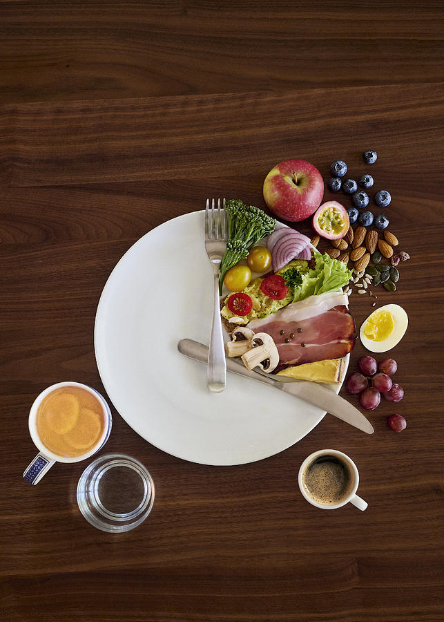 A table setting (on a wooden table) arranged to illustrate the concept of intermittent fasting. Photograph by David Malan