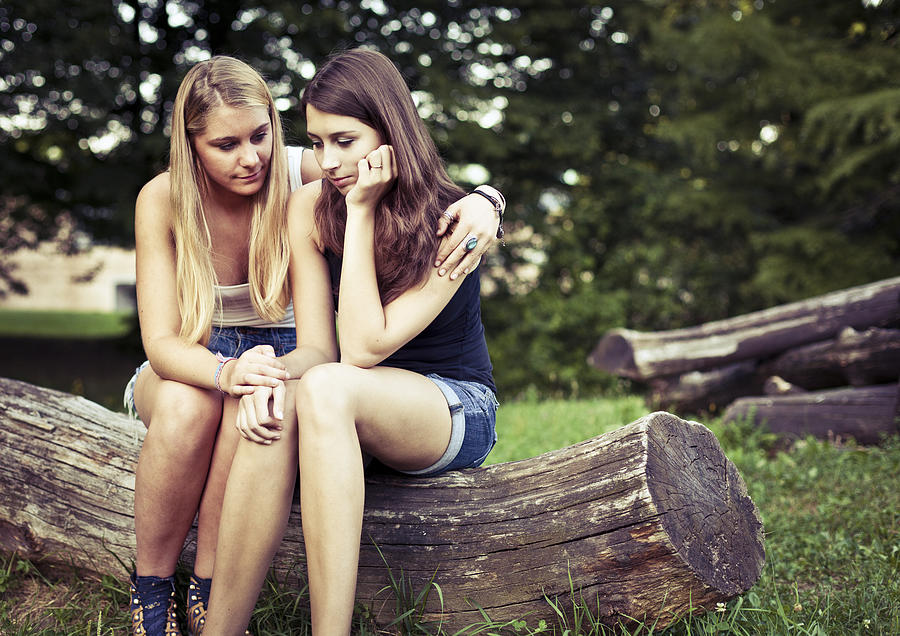 A teenager consoling her friend who looks sad Photograph by Piranka