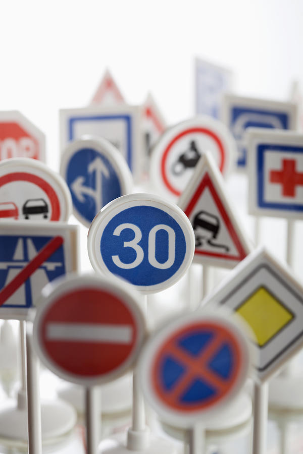 A toy speed limit sign surrounded by other various road warning signs Photograph by Larry Washburn