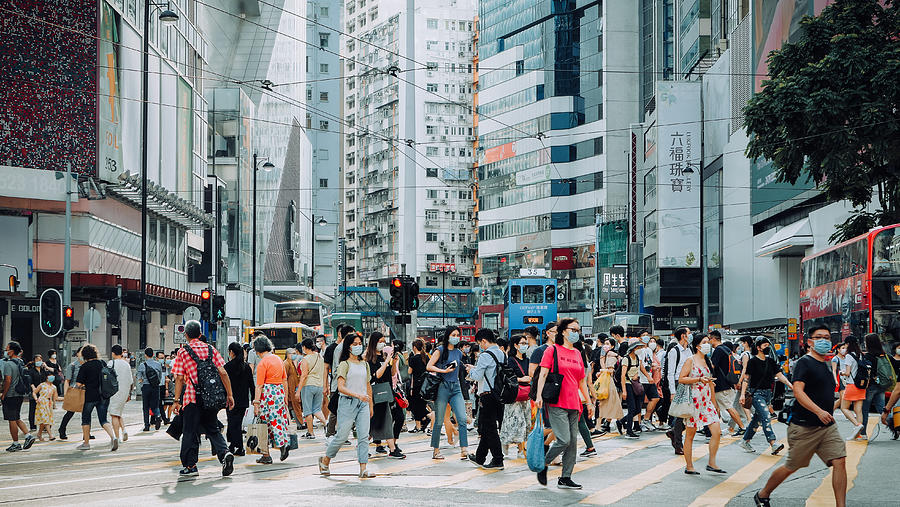 A typical city life in Hong Kong. Crowd of busy commuters crossing the street in downtown district during rush hour against contemporary corporate skyscrapers and city traffic Photograph by Yiu Yu Hoi