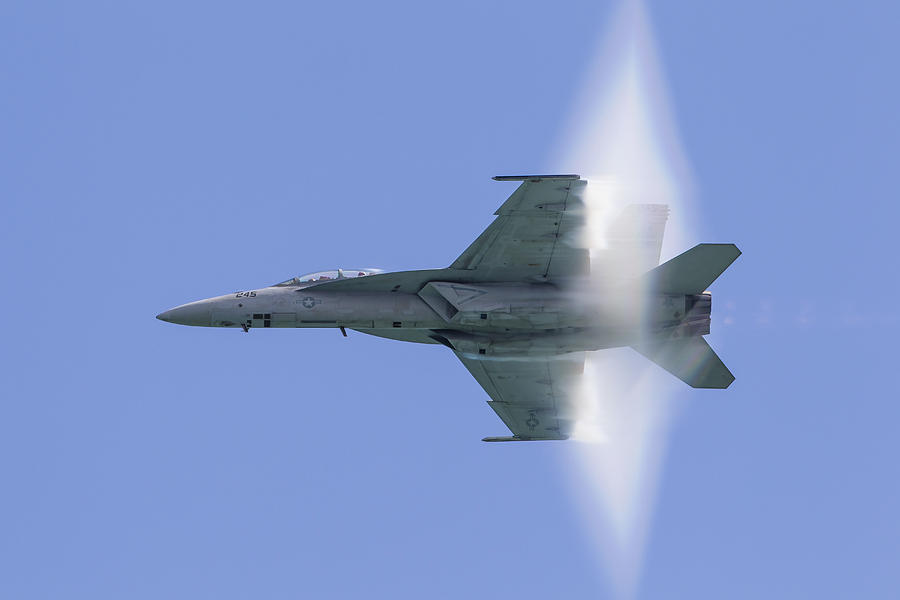 A U.S. Navy F/A-18F Super Hornet flies by at high transonic speed. Photograph by Stocktrek Images