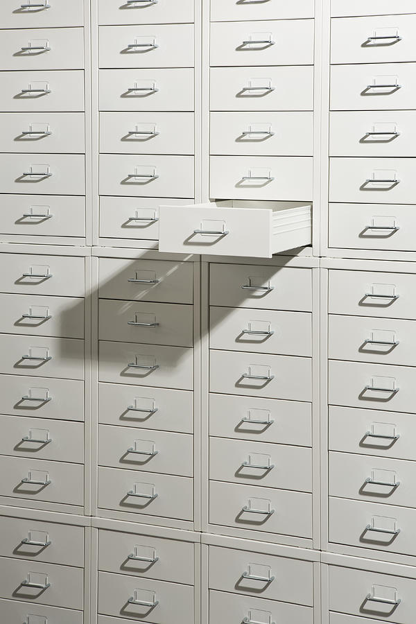 A white cabinet of drawers with one drawer open Photograph by Caspar Benson