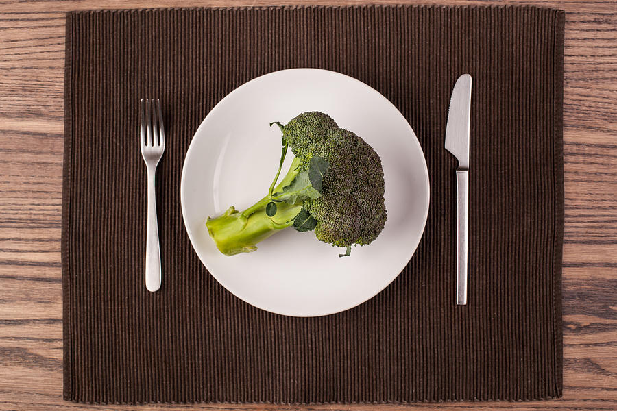 A whole head of broccoli on a plate Photograph by Trevor Williams